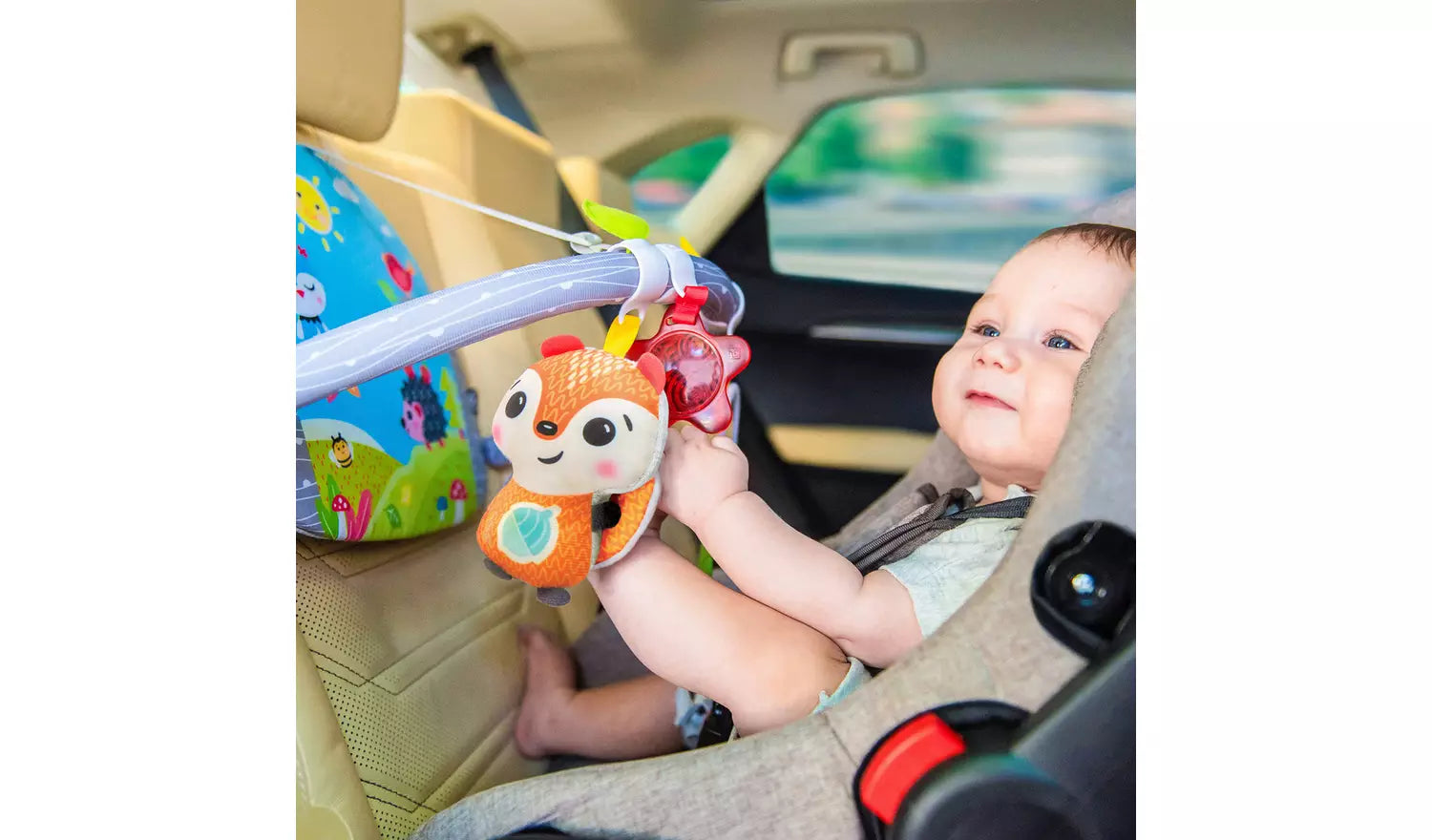 Photo of a young child in a reversed car seat playing with the Benbat Double Sided Car Arch.