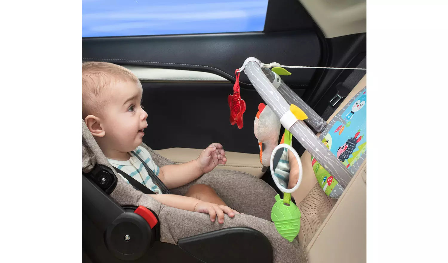 Photo of a young child in a reversed car seat playing with the Benbat Double Sided Car Arch.