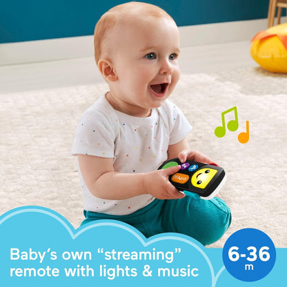 Photo of a young child playing with the Fisher-Price Laugh & Learn Stream & Learn Remote. Baby's own "streaming" remote with lights & music 