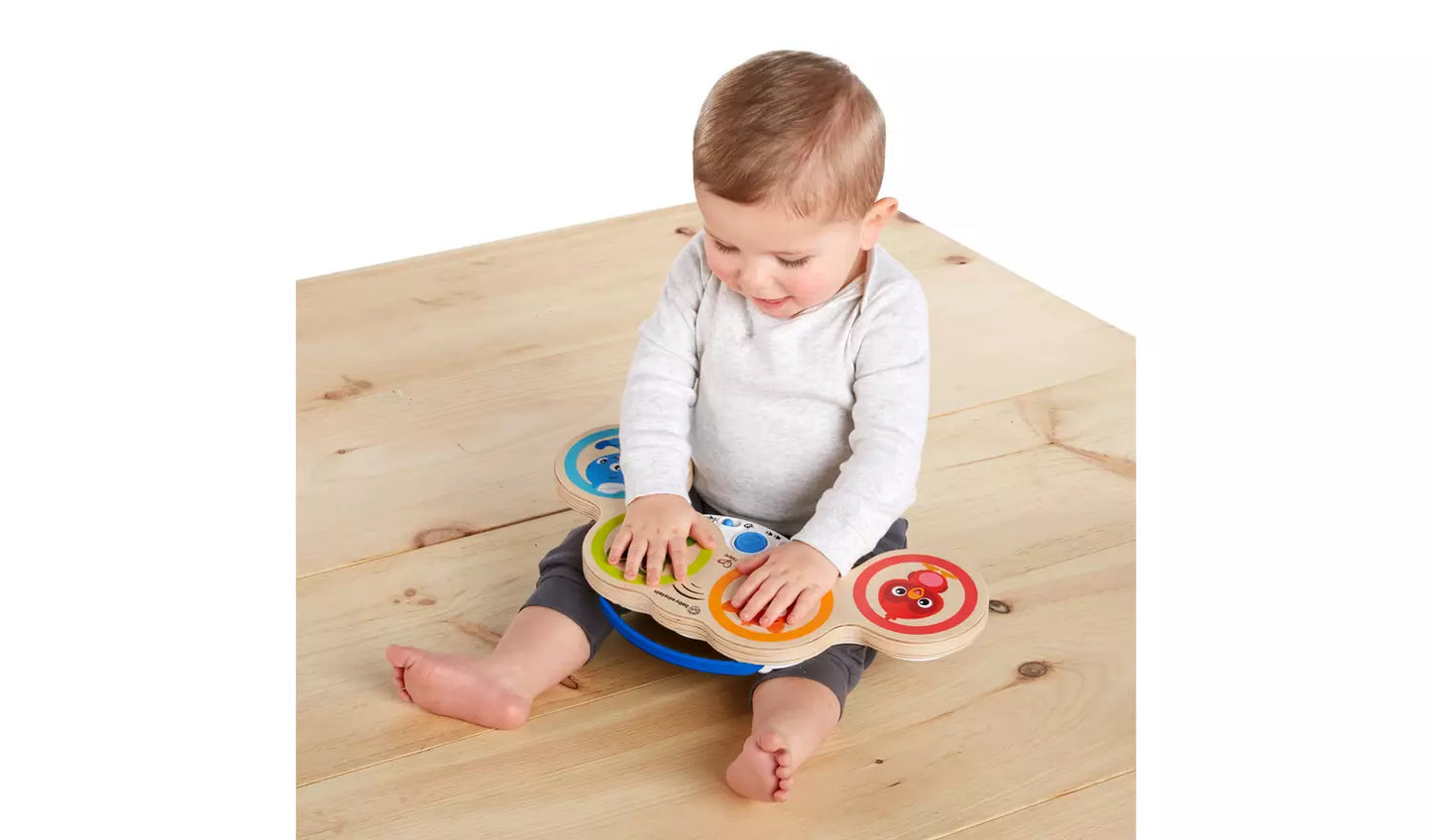 Young child playing with the Baby Einstein Hape Magic Touch Wooden Drums