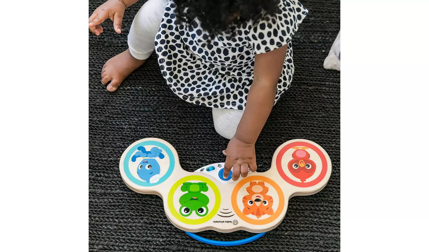 Young child playing with the Baby Einstein Hape Magic Touch Wooden Drums