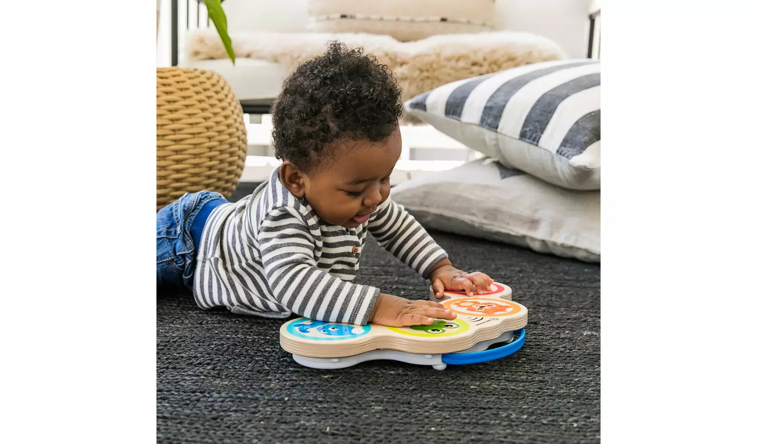 Young child playing with the Baby Einstein Hape Magic Touch Wooden Drums