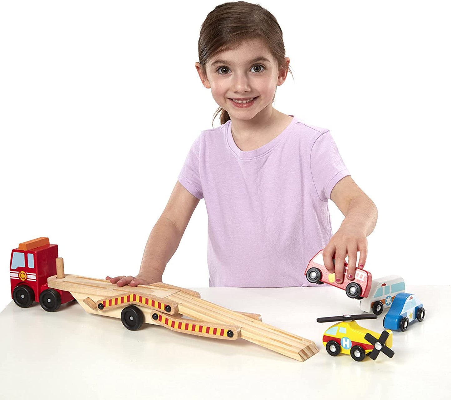 Photo of a young child playing with the Melissa & Doug Wooden Emergency Vehicle Carrier.