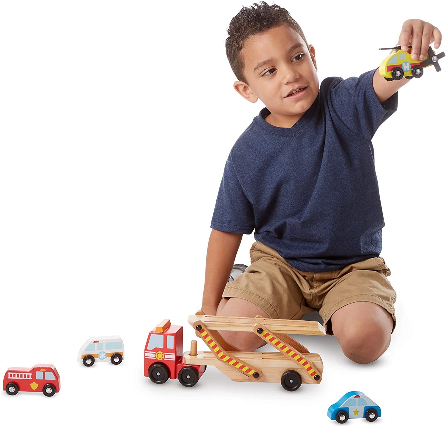 Photo of a young child playing with the Melissa & Doug Wooden Emergency Vehicle Carrier.