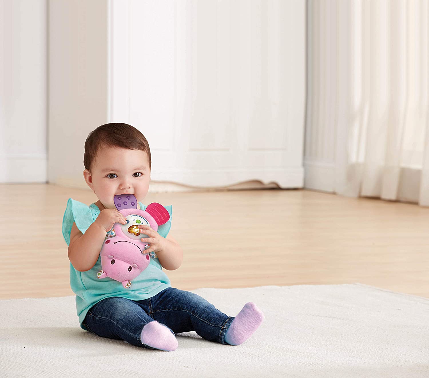 A young child playing with the Vtech Little Friendlies Happy Hippo Teether (Pink)